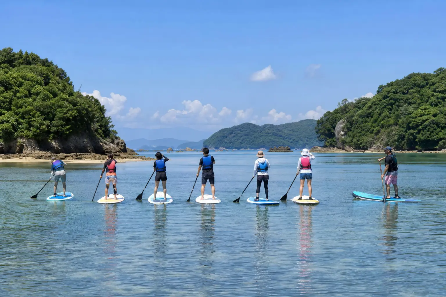 浅瀬を横一列に進むSUPと、並走する指導者（撮影イメージ）